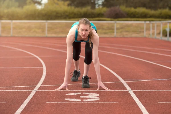 Young woman sprinter in the starter position — Stock Photo, Image