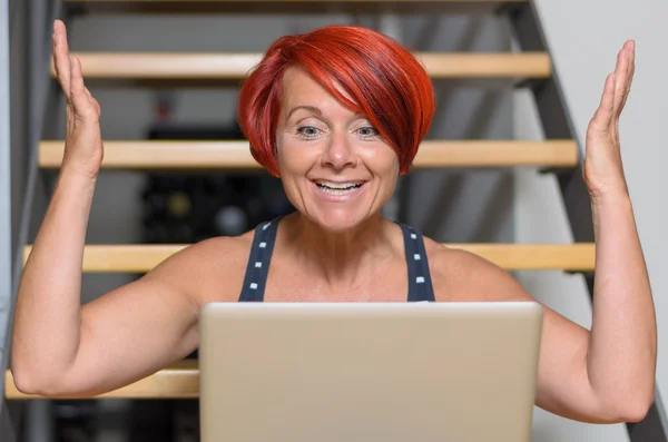 그녀의 팔을 제기 하는 노트북으로 행복 한 성인 여자 — 스톡 사진