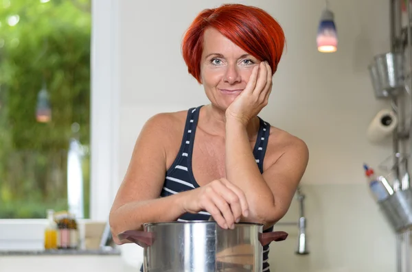 Mujer sonriente apoyando sus brazos en la olla de cocina —  Fotos de Stock