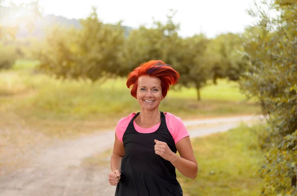 Mujer sana feliz trotando a lo largo de camino al aire libre — Foto de Stock