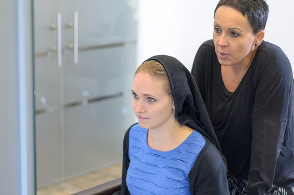 Parrucchiere donna spiegando ad una cliente femminile — Foto Stock