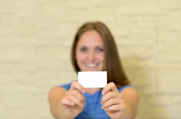 Young woman holding out a business card
