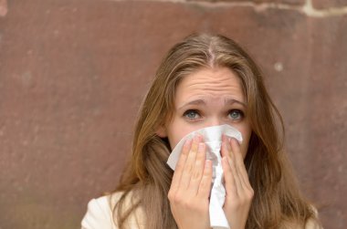 Genç kadın bir mendil burnunda üfleme