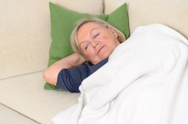 Close up Middle Aged Blond Woman Resting on Couch clipart