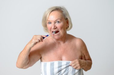 Kadın kıdemli havlu fırçalama diş sarılmış