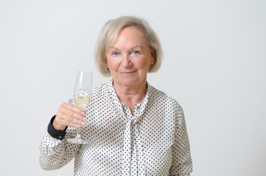 Senior woman toasting with champagne clipart