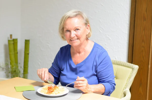 Senior woman eating a meal — Stock Photo, Image