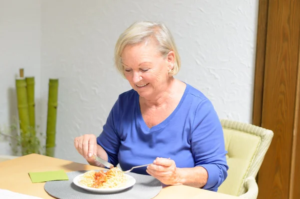 Senior woman eating a meal — Stock Photo, Image