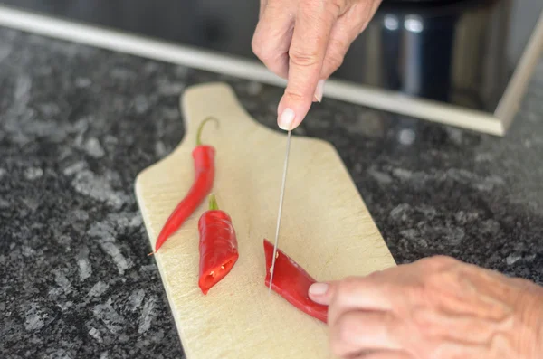 Anciana rebanando chiles rojos —  Fotos de Stock