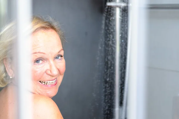 Smiling attractive senior woman taking a shower — Stock Photo, Image