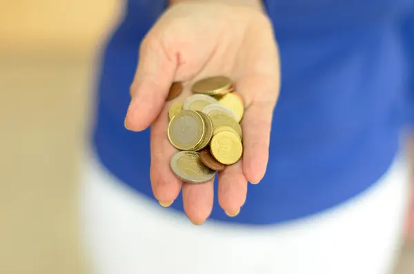 Woman holding loose change in her hand