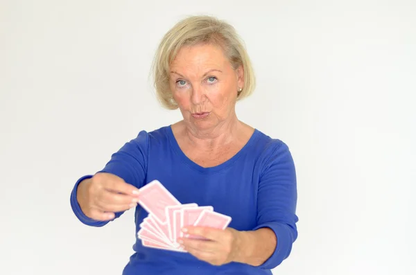 Улыбающаяся женщина держит руку игральных карт — стоковое фото
