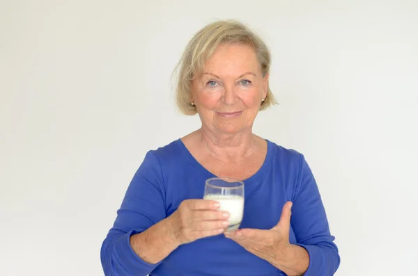 Healthy senior lady drinking fresh milk — Stock Photo, Image