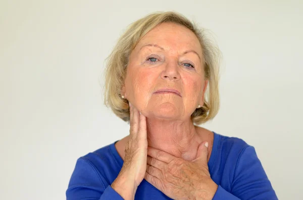 Thoughtful elderly woman with her hand to her neck — Stock Photo, Image