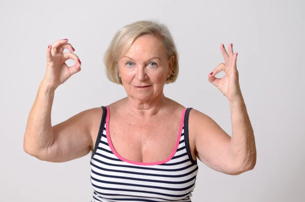 Mujer de mediana edad mostrando dos señales de mano bien —  Fotos de Stock