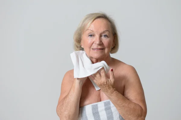 Женщина средних лет вытирает шею полотенцем — стоковое фото