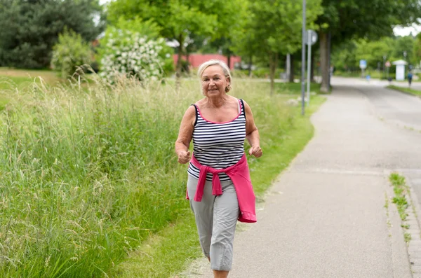 Mujer sana de mediana edad corriendo en la calle — Foto de Stock