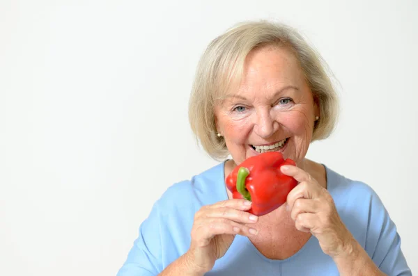 Happy healthy senior lady with a red pepper — Stock Photo, Image