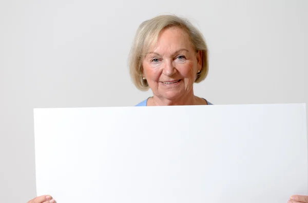 Elderly lady showing a blank whiteboard — Stock Photo, Image
