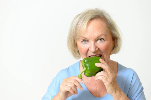 Happy healthy senior lady with a green pepper — Stock Photo, Image