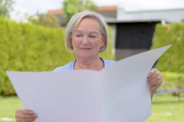 Oudere dame houdt van een blanco papier — Stockfoto
