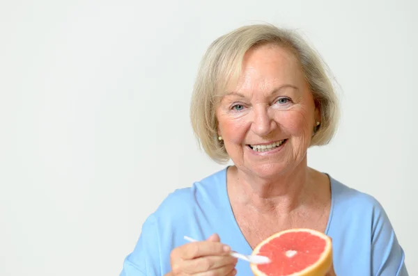 Happy healthy senior lady with a orange — Stock Photo, Image