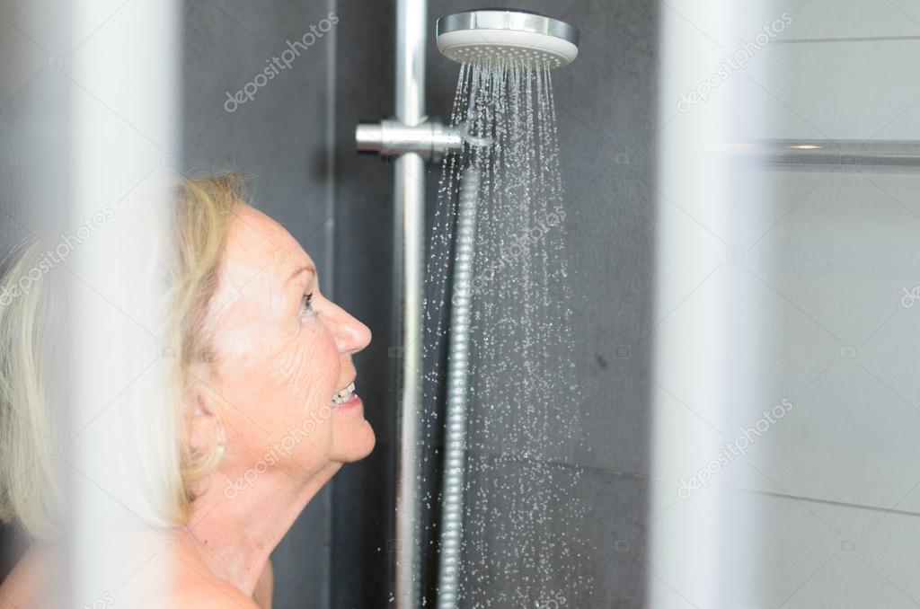 Smiling attractive senior woman taking a shower