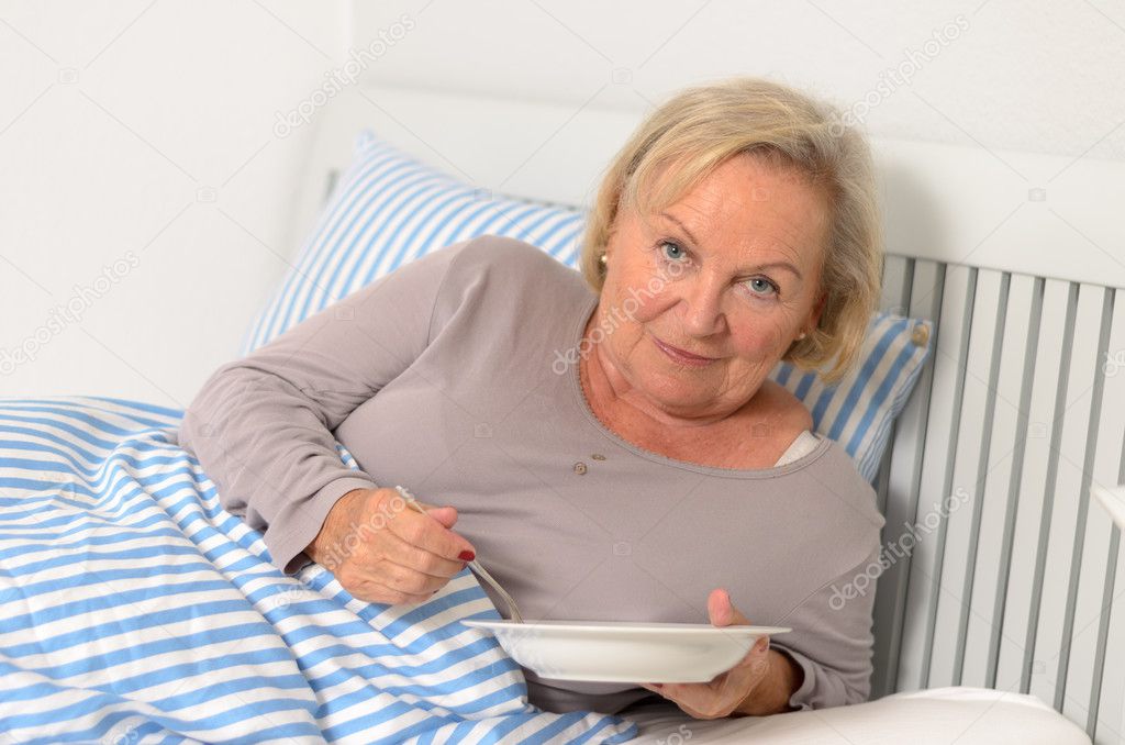 Adult Blond Woman on her Bed Holding her Food