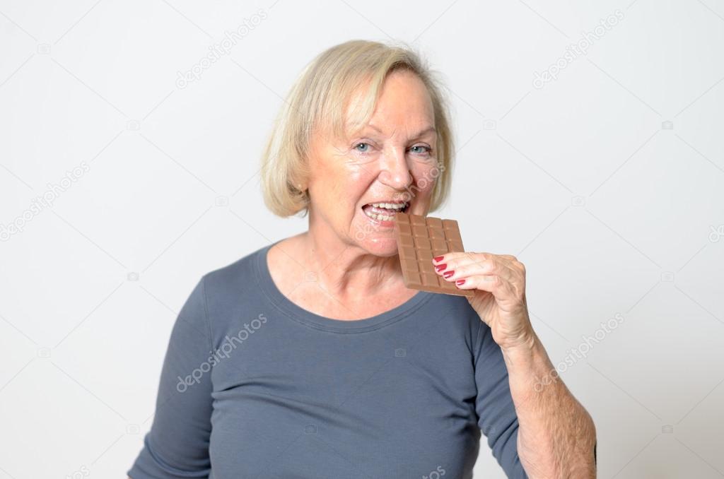 Adult Blond Woman Eating Chocolate Bar in Close up