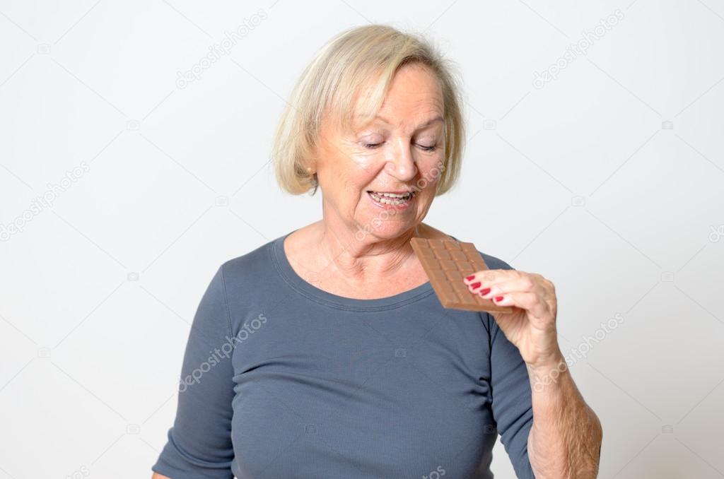 Adult Blond Woman Eating Chocolate Bar in Close up