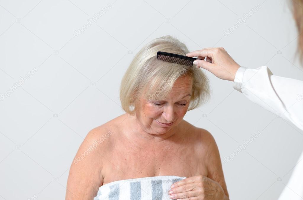 Elderly lady gets her hair combed