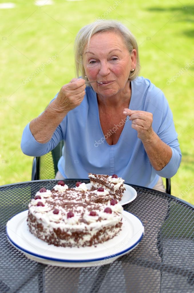 Elderly lady enjoying a slice of cake — Stock Photo © info.michaelheim