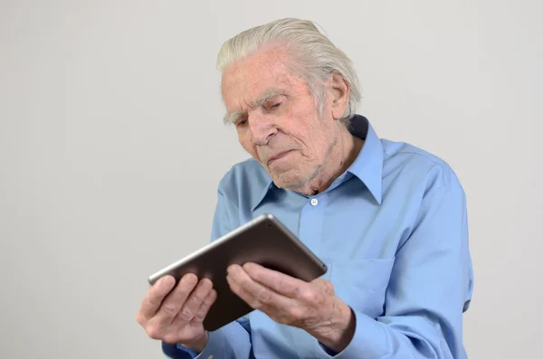 Elderly man holding a modern tablet PC — Stock Photo, Image
