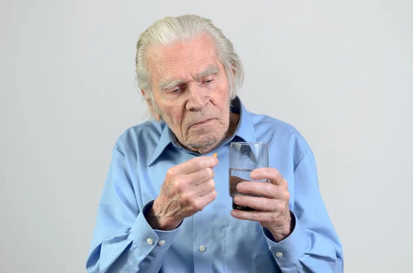 Senior man taking the prescribed dose of medicine — Stock Photo, Image