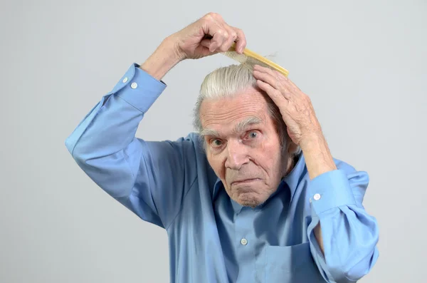 Uomo anziano attivo pettinarsi i capelli con un pettine — Foto Stock