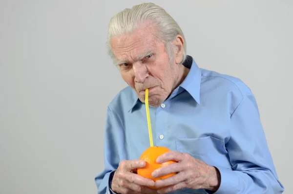 Senior man drinking fresh orange juice — Stock Photo, Image