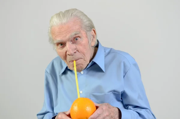 Senior man drinking fresh orange juice — Stock Photo, Image