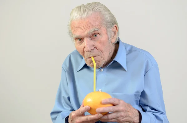 Senior man drinking fresh grapefruit juice — Stock Photo, Image