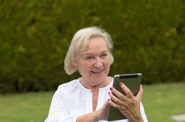 Senior serene woman using a black tablet PC — Stock Photo, Image