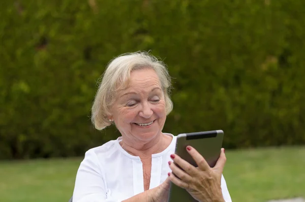 Senior serene woman using a black tablet PC — Stock Photo, Image