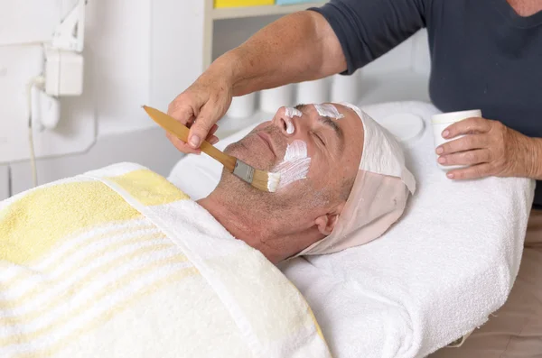 Man at beauty center receiving facial treatment