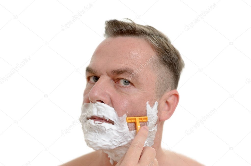Man shaving his beard with a razor and lather