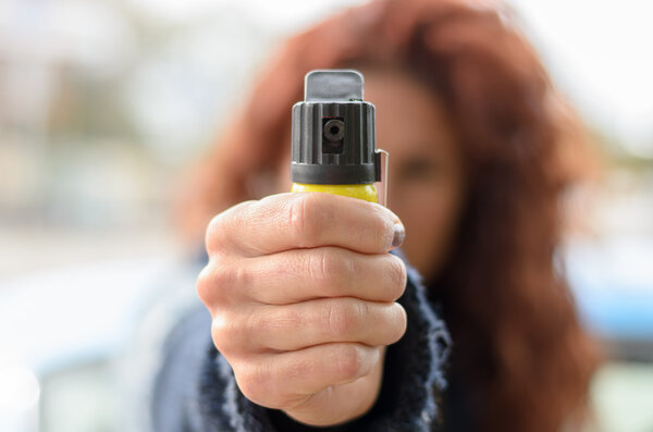 Close up of pepper spray in hand of woman