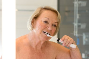 Yaşlı üstsüz Bayan dişlerini Temizleme