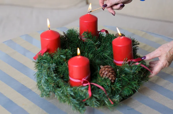 Donna che accende candele su una ghirlanda di Natale — Foto Stock