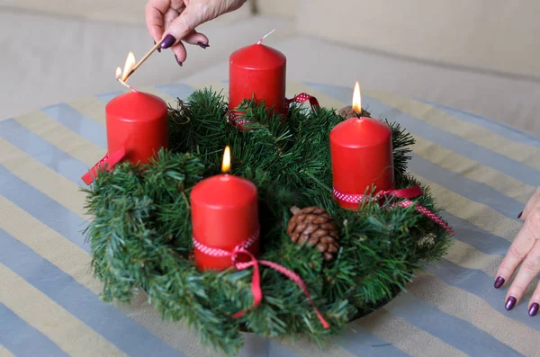 Donna che accende candele su una ghirlanda di Natale — Foto Stock