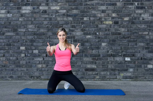 Fit woman giving double thumb up