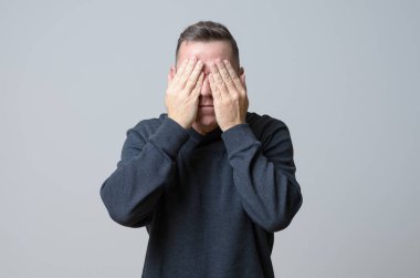 Adam yüzünü kapatıyor.