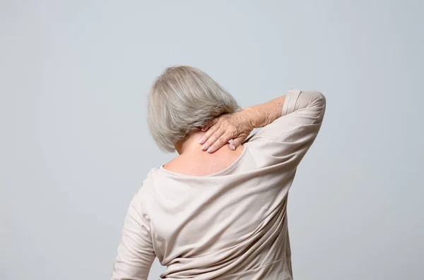 Senior woman touching her neck — Stock Photo, Image