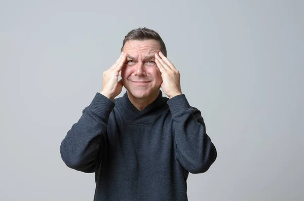 Frustrated man with his hands to his temples — Stock Photo, Image